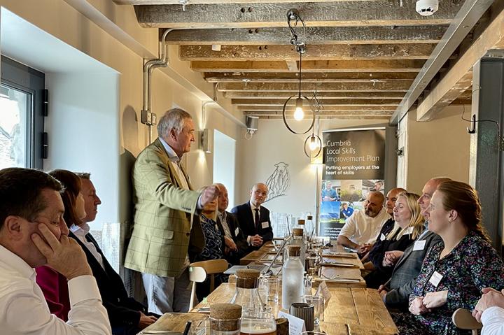 Tony McPhillips speaking to guests around a table