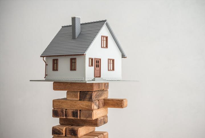 House balancing on Jenga tower