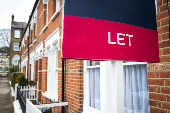 A red 'let' sign outside of a row of terraced houses