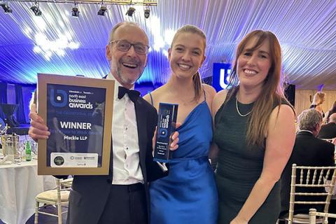 a man and two women holding certificate in a frame