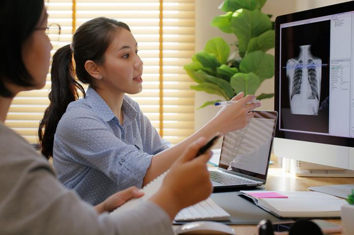 doctor showing patent and x ray on a screen