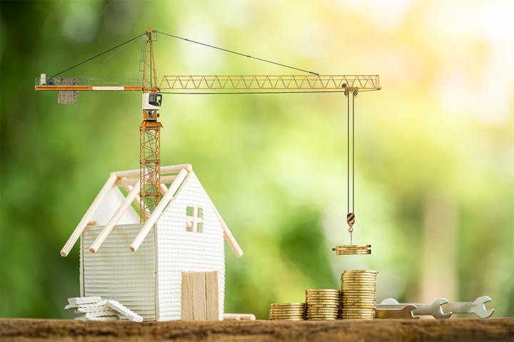 A model of a house which has a crane coming out of it and lifting coins