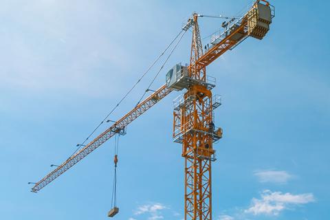 A yellow construction crane over a blue sky