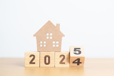 Wooden blocks displaying 2024/5 with a model wooden house on top