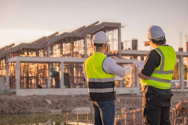 Two construction workers evaluating a site 