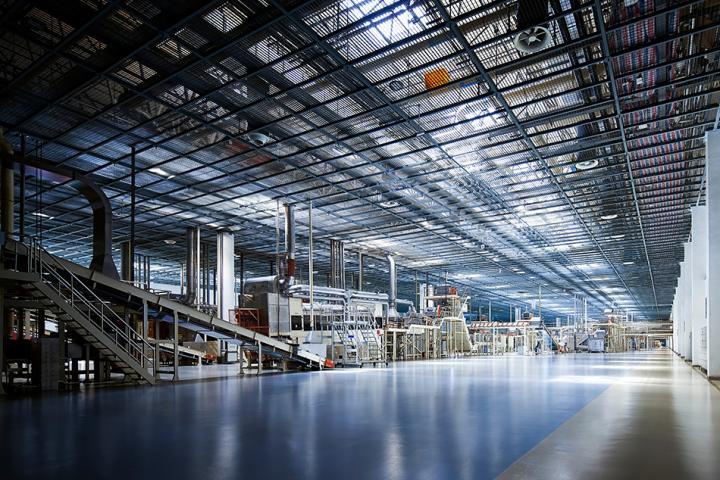 Internal photo of a generic industrial factory space, with machinery faintly visible in the background