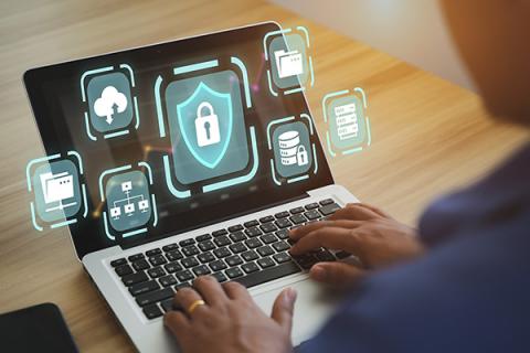 Man using laptop with various tech infographics super imposed over the top