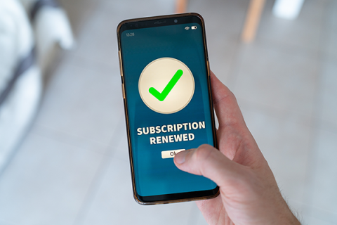 A mobile phone with a subscription renewed alert on the screen