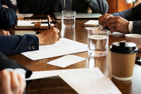 Four individuals engaging in a board meeting